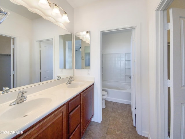 bathroom featuring tile patterned floors, vanity, toilet, and a tub to relax in