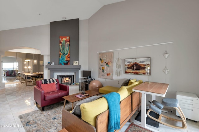 living room with a fireplace and high vaulted ceiling