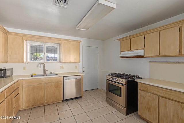 kitchen with sink, light tile patterned floors, stainless steel appliances, and light brown cabinetry