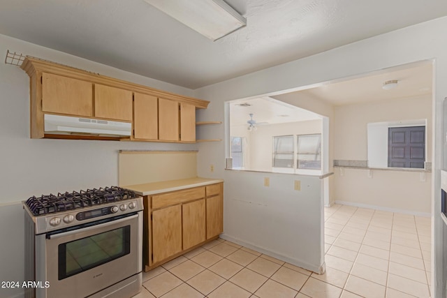 kitchen featuring stainless steel range, light tile patterned floors, and light brown cabinets