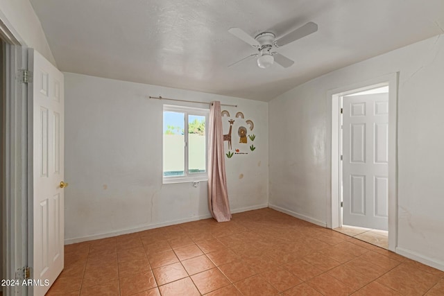 tiled spare room featuring ceiling fan