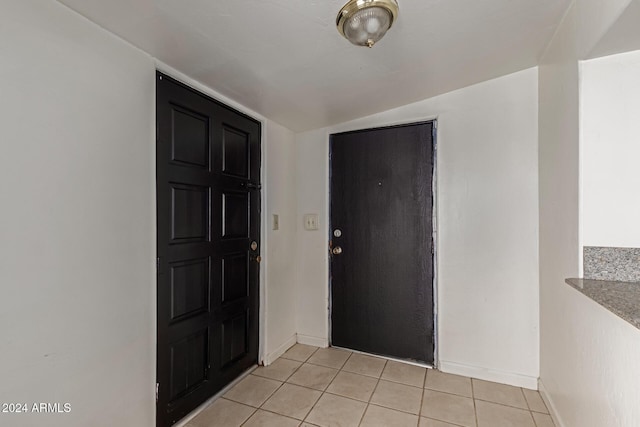 tiled foyer featuring lofted ceiling