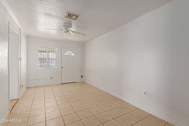 foyer entrance with ceiling fan and light tile patterned floors