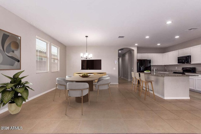 tiled dining area featuring a chandelier