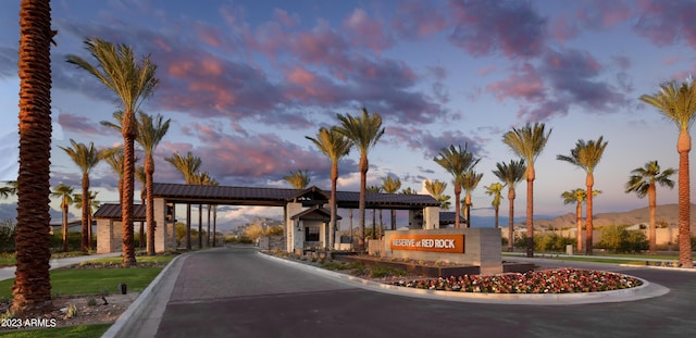 view of road featuring curbs, a mountain view, and a gated entry