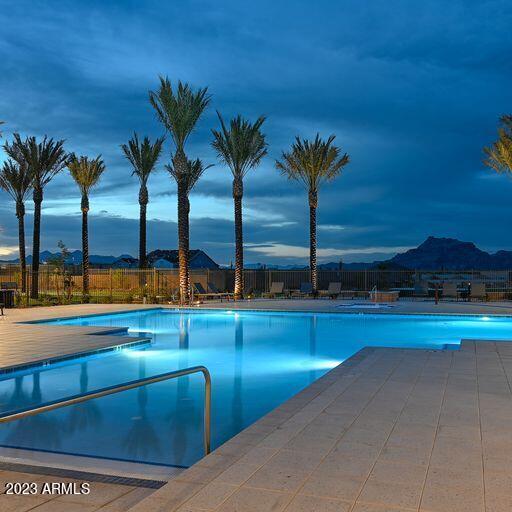 community pool with a patio area and fence