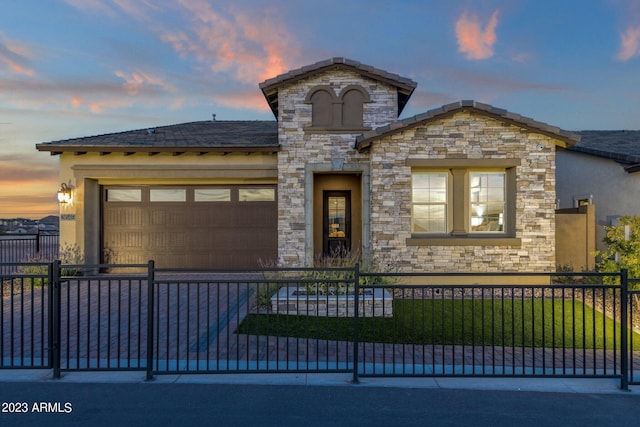 view of front of house featuring an attached garage, stone siding, a fenced front yard, and stucco siding