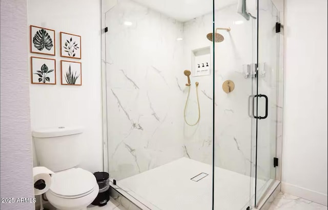 full bathroom featuring marble look tile flooring, toilet, a marble finish shower, and baseboards
