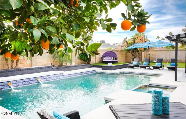 view of swimming pool with a fenced backyard, a pool with connected hot tub, and a patio area
