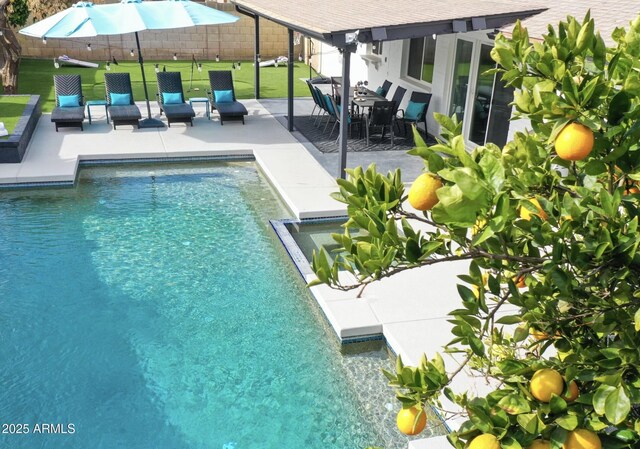 view of swimming pool with a patio, fence, and a pool with connected hot tub