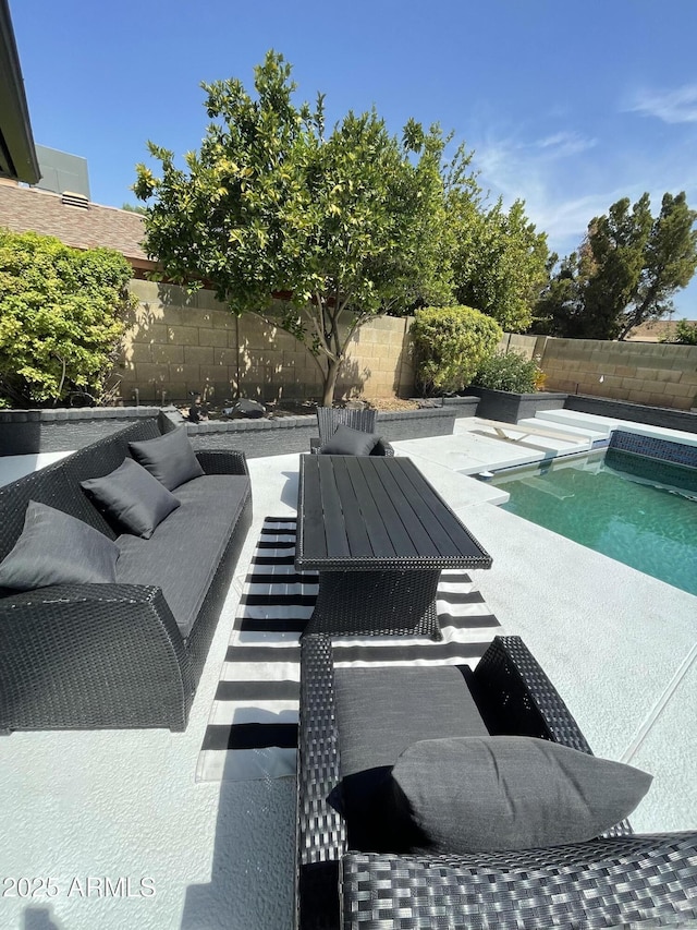 view of pool with a fenced backyard, a patio, and an outdoor living space