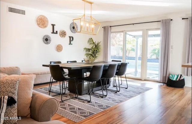 dining area featuring wood finished floors and a chandelier
