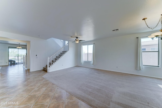 7398 W Paso Trl, Peoria, AZ 85383 - unfurnished living room with stairway, healthy amount of natural light, ceiling fan, and light colored carpet
