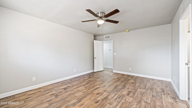 unfurnished bedroom featuring a ceiling fan, visible vents, wood finished floors, and baseboards