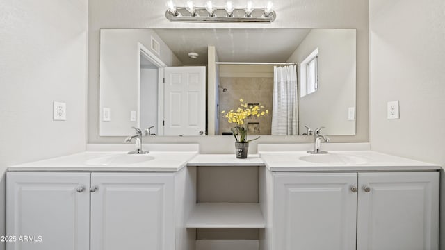 bathroom featuring two vanities, visible vents, and a sink