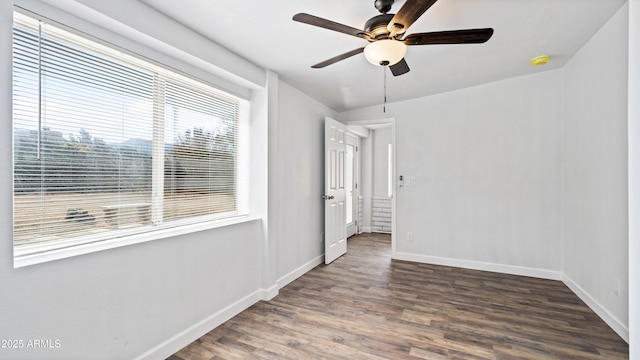 empty room with a ceiling fan, baseboards, and wood finished floors