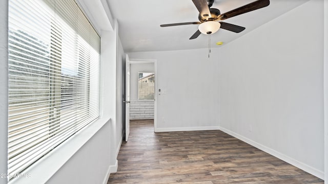 spare room featuring ceiling fan, dark wood-type flooring, and baseboards