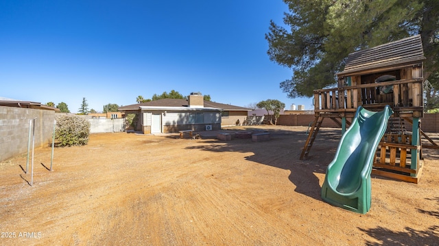 view of yard with a fenced backyard and a playground