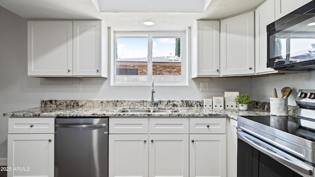 kitchen featuring a sink, light stone countertops, appliances with stainless steel finishes, and white cabinetry