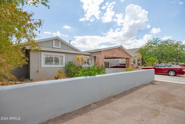 ranch-style house featuring brick siding, a fenced front yard, and stucco siding