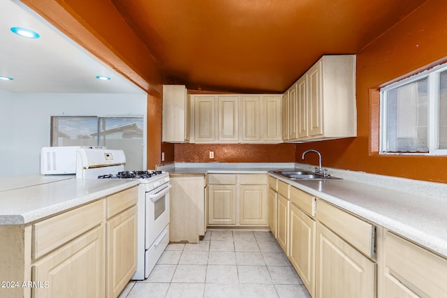 kitchen featuring vaulted ceiling, white appliances, light brown cabinetry, sink, and light tile patterned flooring