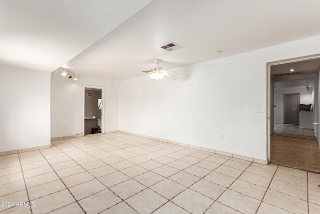 spare room with a ceiling fan, visible vents, baseboards, and light tile patterned floors