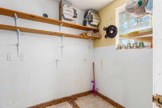 laundry room featuring baseboards and light tile patterned floors