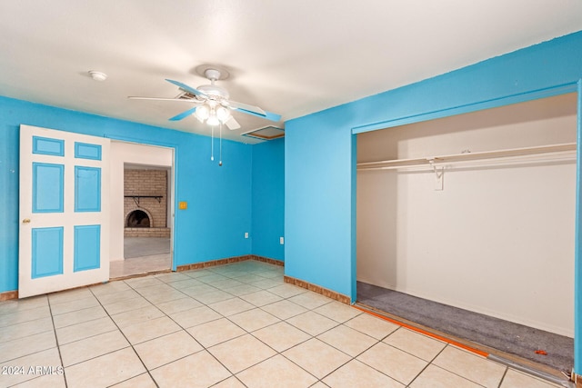 unfurnished bedroom with a ceiling fan, a fireplace, baseboards, and a closet