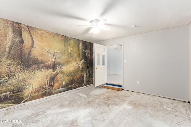 empty room with a ceiling fan and concrete floors