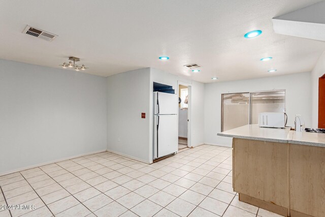 kitchen featuring light tile patterned floors and white appliances