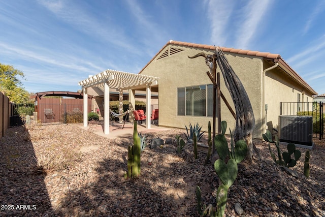 back of house with a pergola, a patio area, and central air condition unit