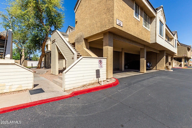 exterior space featuring stairway and stucco siding