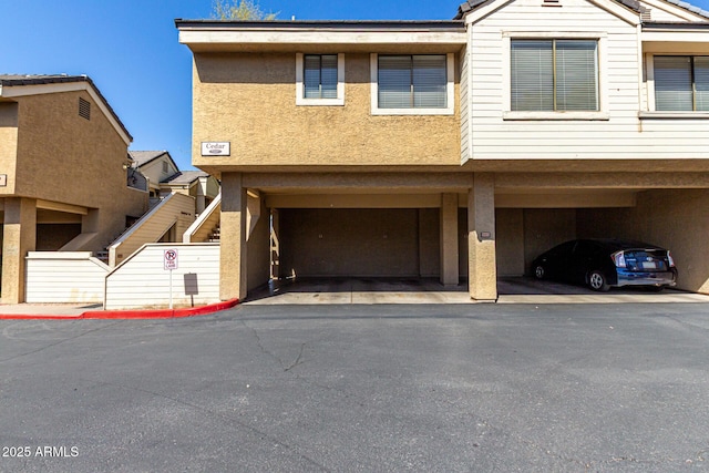 view of property featuring stucco siding and covered parking