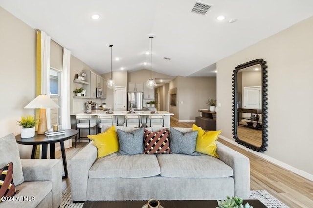 living room with light wood-type flooring and vaulted ceiling