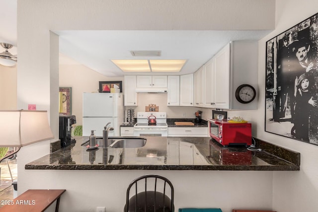 1916 W Morningside Dr Unit 108, Phoenix, AZ 85023 - kitchen with a sink, white appliances, dark stone counters, a peninsula, and visible vents