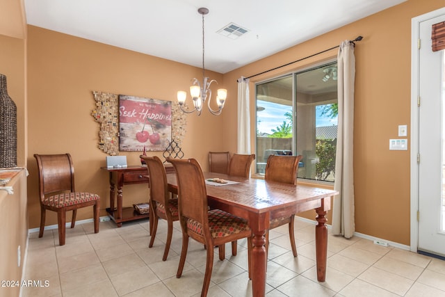 dining room with light tile patterned floors and a chandelier