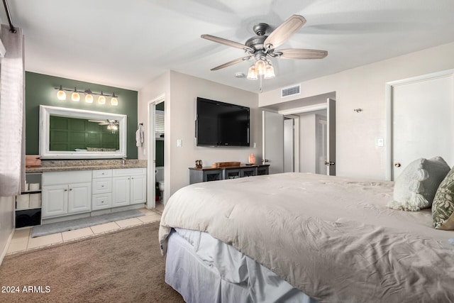 carpeted bedroom featuring ensuite bathroom, ceiling fan, and sink