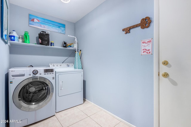 laundry area with light tile patterned flooring and washing machine and dryer