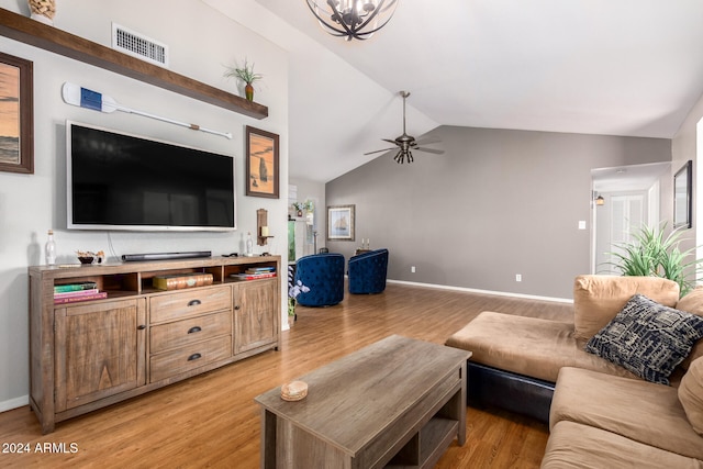 living room with ceiling fan with notable chandelier, light wood-type flooring, and high vaulted ceiling