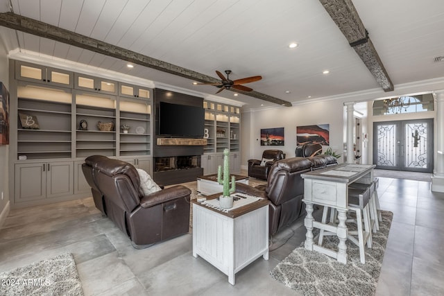 living room with built in shelves, ceiling fan, french doors, decorative columns, and a fireplace