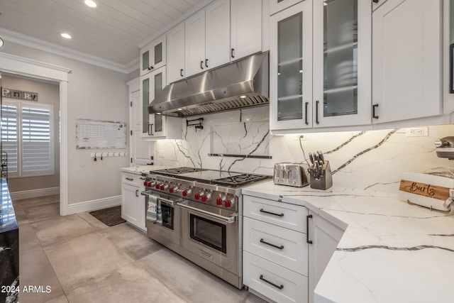 kitchen with light stone countertops, white cabinetry, double oven range, and ornamental molding