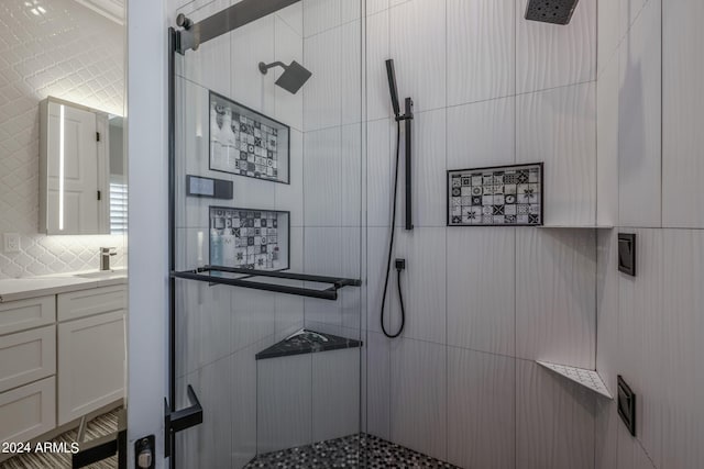 bathroom with backsplash, vanity, and tiled shower