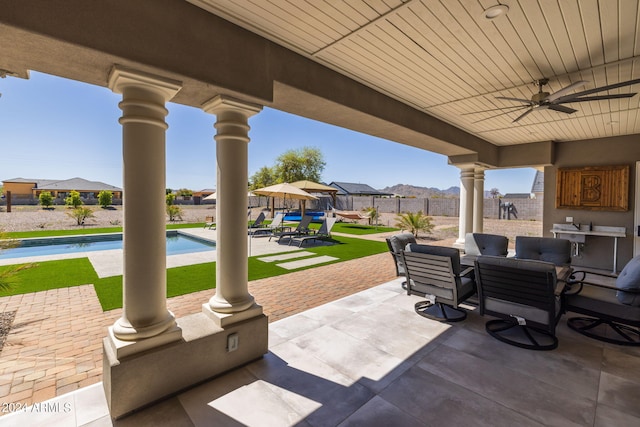 view of patio with a fenced in pool and ceiling fan