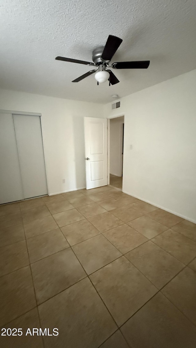 4217 W Medlock Dr, Phoenix, AZ 85019 - empty room featuring light tile patterned floors, a ceiling fan, and a textured ceiling