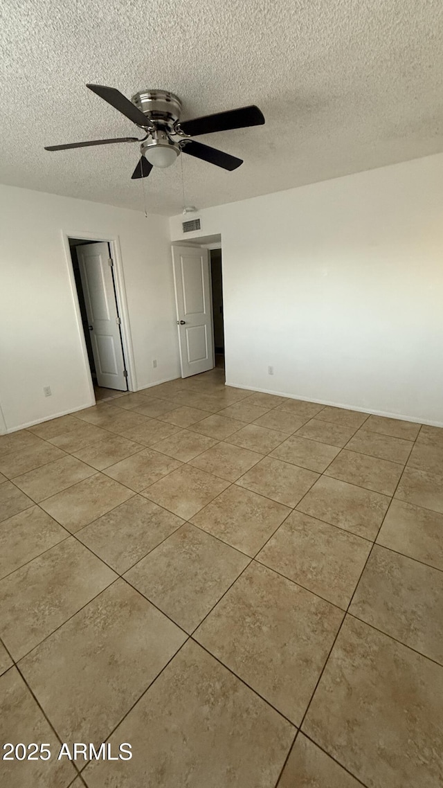 4217 W Medlock Dr, Phoenix, AZ 85019 - spare room featuring a textured ceiling, light tile patterned flooring, and a ceiling fan