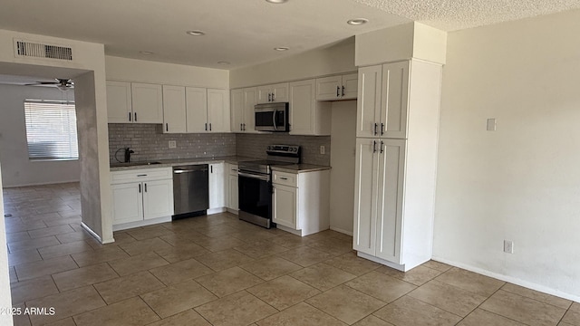 4217 W Medlock Dr, Phoenix, AZ 85019 - kitchen featuring stainless steel appliances, backsplash, white cabinetry, light tile patterned floors, and a ceiling fan