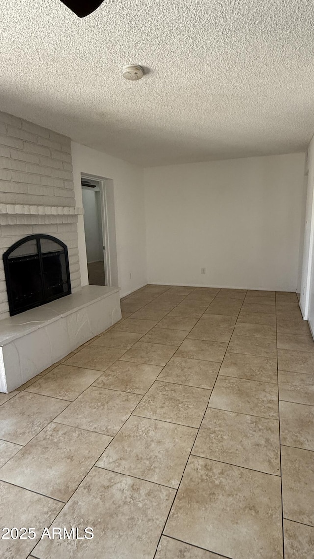 4217 W Medlock Dr, Phoenix, AZ 85019 - unfurnished living room featuring a textured ceiling, a fireplace, and tile patterned flooring