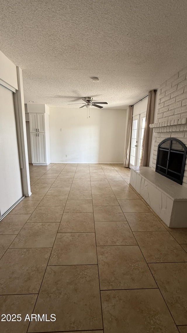 4217 W Medlock Dr, Phoenix, AZ 85019 - unfurnished living room with tile patterned floors, a fireplace, ceiling fan, and a textured ceiling