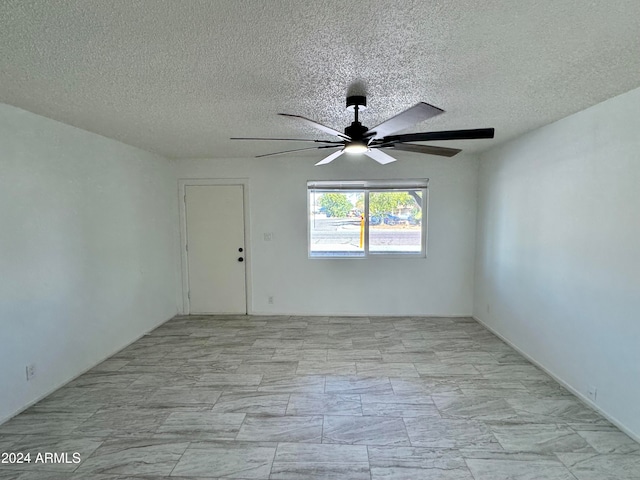 spare room featuring a textured ceiling and ceiling fan