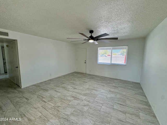 spare room featuring ceiling fan and a textured ceiling